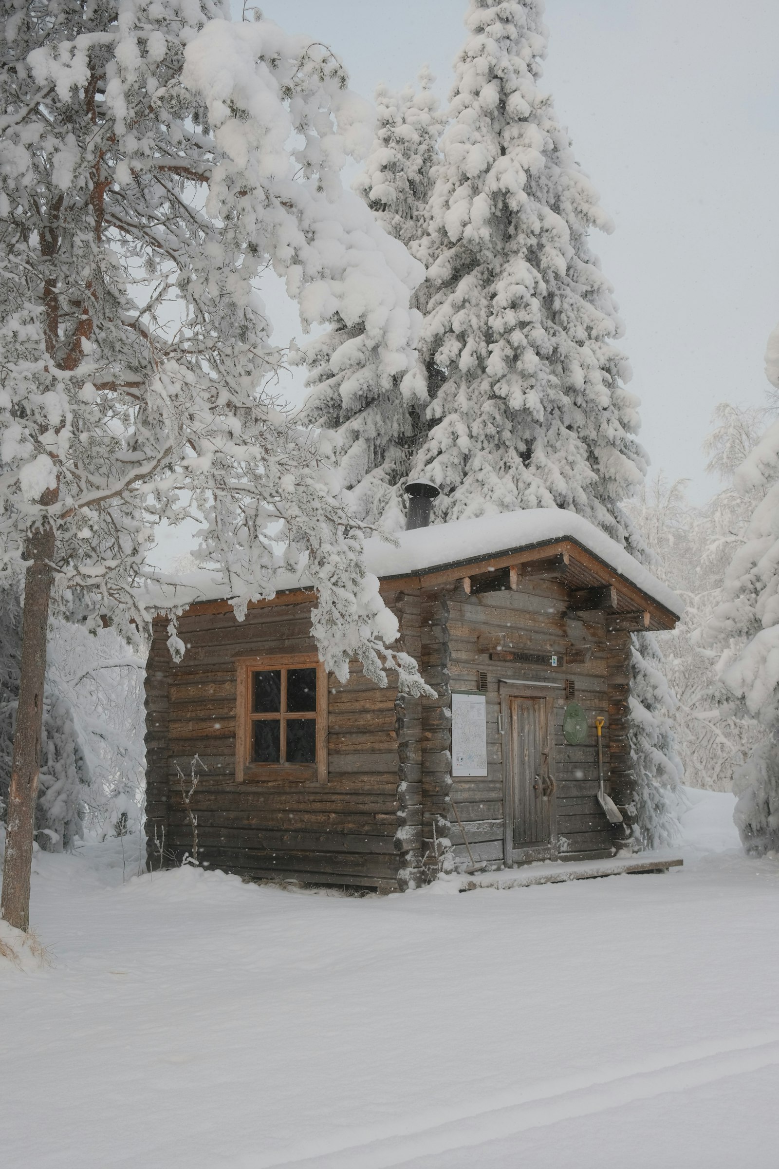Skandinavische Holzh&uuml;tte zwischen frostbedeckten B&auml;umen