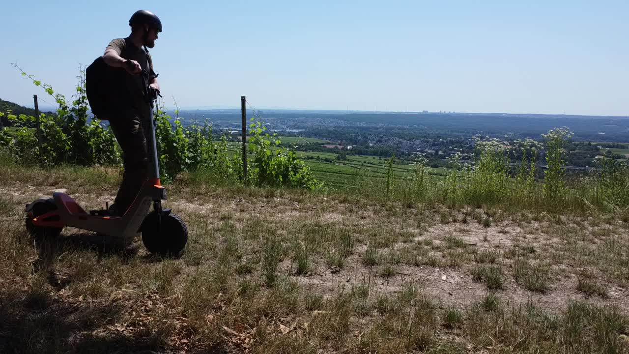 Fahrer mit dem Castor am Hangrand, Tal im Hintergrund
